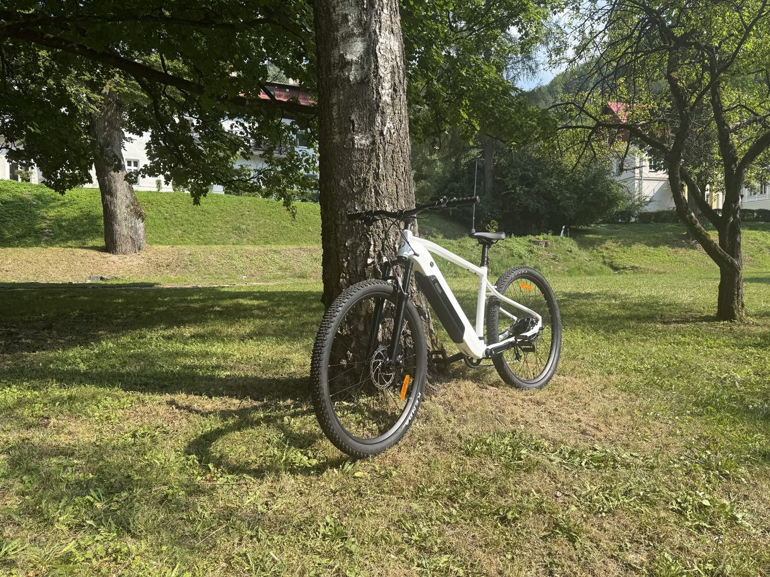 Horský elektrobicykel Rockrider E-EXPL 100 opretý o brezu na tráve v Ľubochni